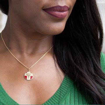 detail of gold and red, round, embossed, and vintage style medical id pendant on chain
